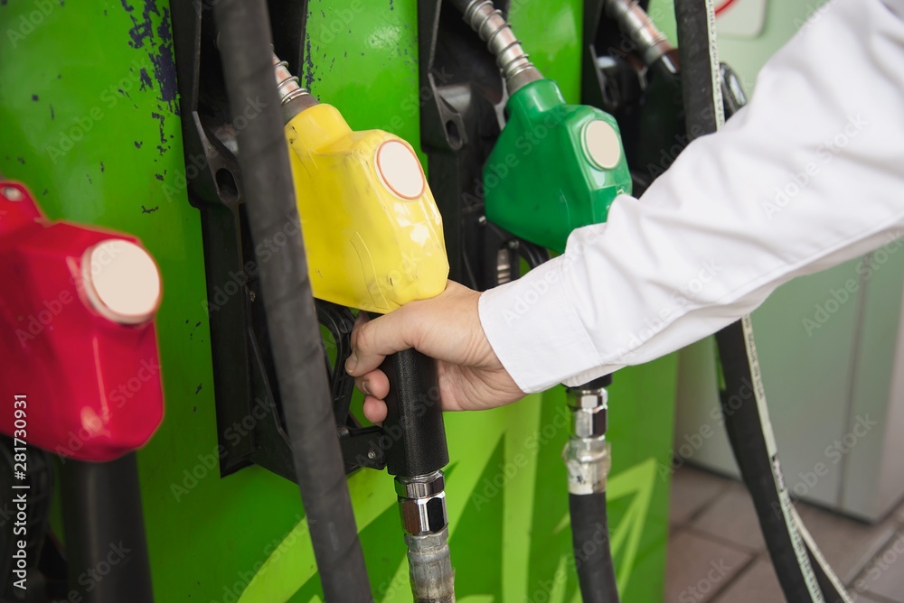 Man putting gasoline fuel into his car in a pump gas station Man putting gasoline fuel into his car in a pump gas station