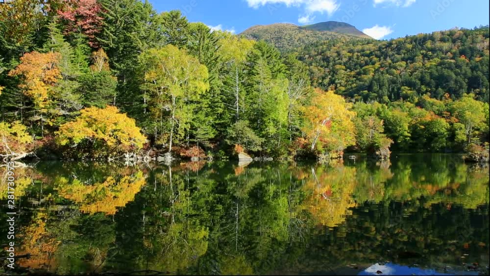 Lake Akan with forest on shore in autumn, Kushiro, Hokkaido, Japan Lake Akan with forest on shore in autumn, Kushiro, Hokkaido, Japan