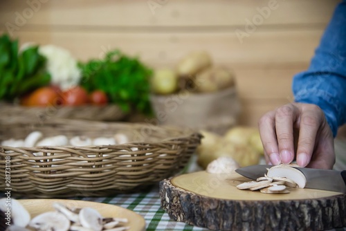 Lady cooks fresh champignon mushroom vegetable in the kitchen - people with vegetable cooking concept