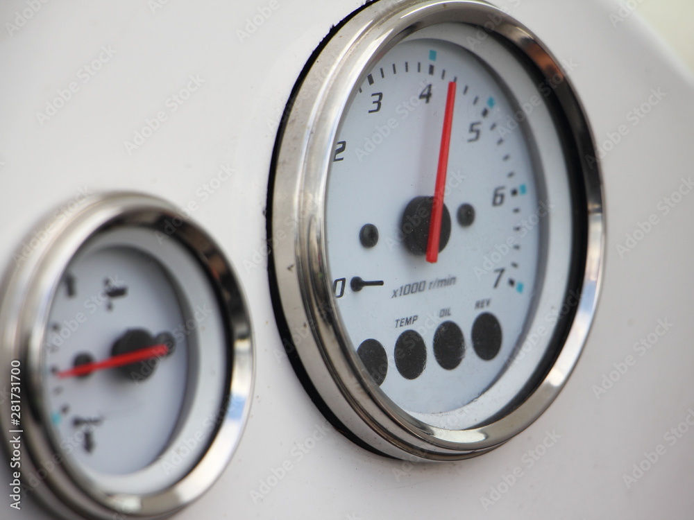 Main analog devices on the white dashboard control panel of the motor boat close-up: tachometer with 4200 rpm and trim meter Main analog devices on the white dashboard control panel of the motor boat close-up: tachometer with 4200 rpm and trim meter