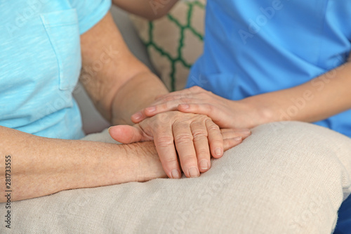Nurse holding elderly woman's hands, closeup. Assisting senior people