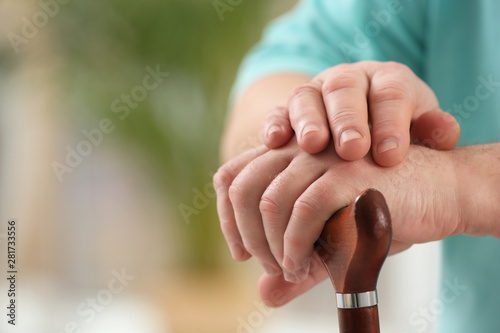 Closeup view of elderly man with cane in nursing home  space for text. Assisting senior generation