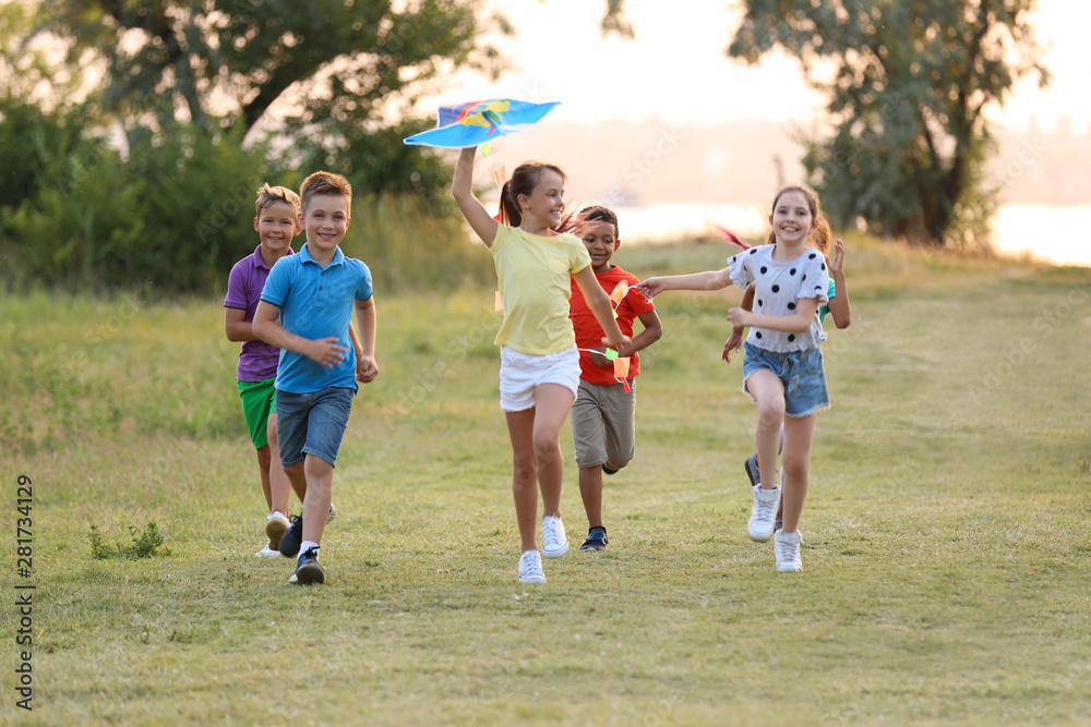 Cute little children playing with kite outdoors