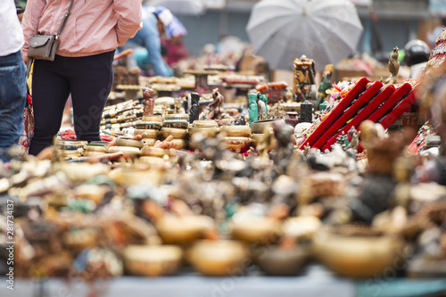 (Selective focus) Close-up view of some souvenirs (singing bowls, hand created statues and Rudraksha necklace) on a street market stall in Kathmandu Durbar Square, Kathmandu, Nepal.