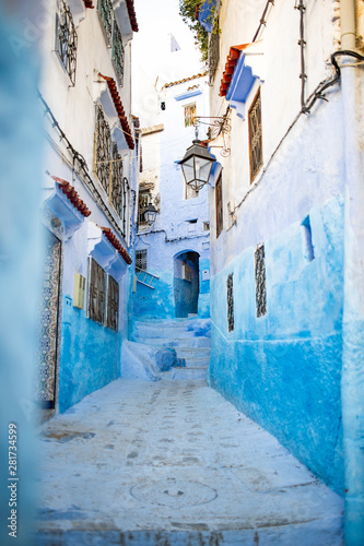 Stunning view of a narrow alleyway with the striking, blue-washed buildings. Chefchaouen, or Chaouen, is a city in the Rif Mountains of northwest Morocco. © Travel Wild