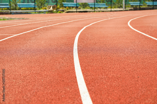 Red running track with white lines outdoor, copy space