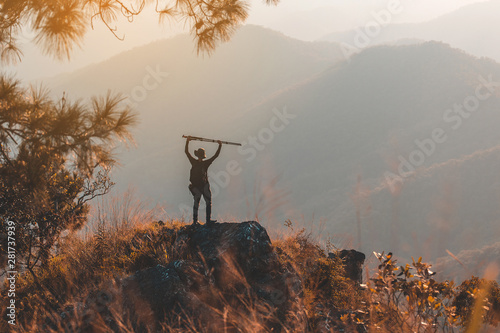 Silhouette of man hold up hands on the peak of mountain,success concept