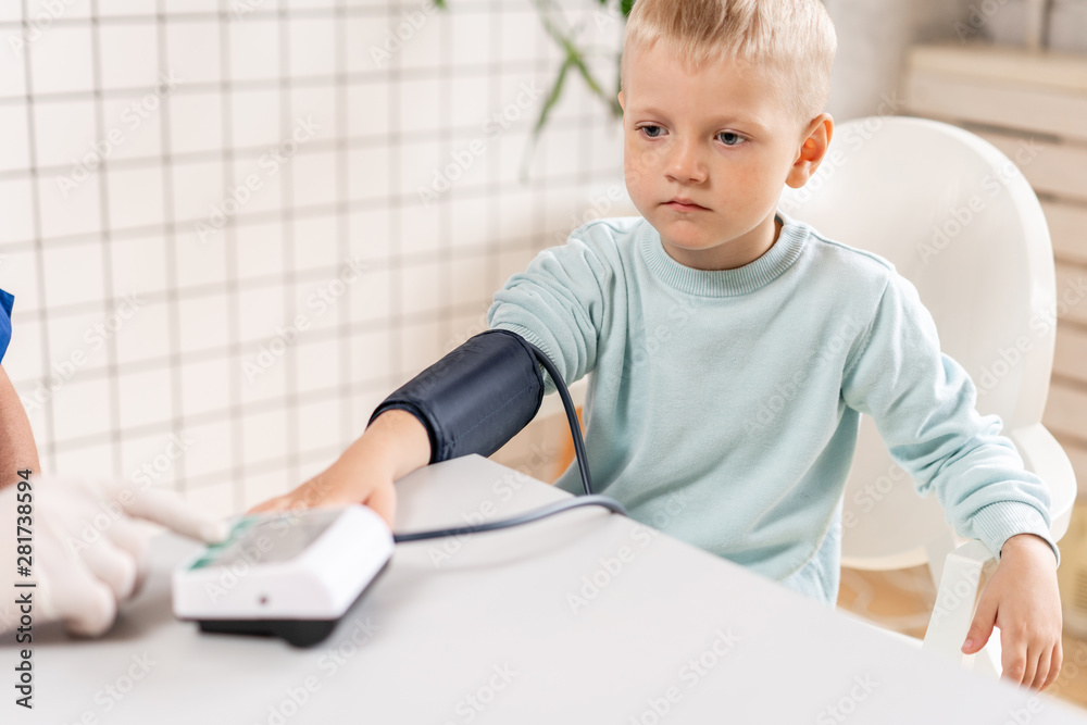 Doctor measuring blood pressure of a little boy. Diagnostic, healthcare, medical service. Doctor pediatrician concept Doctor measuring blood pressure of a little boy. Diagnostic, healthcare, medical service. Doctor pediatrician concept