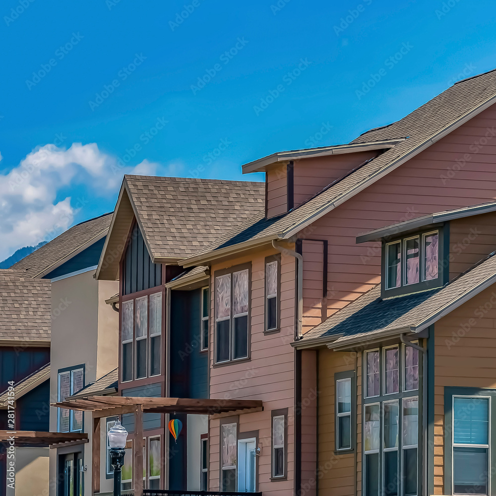 Row of homes with porches and balcony against mountain and sky on a sunny day