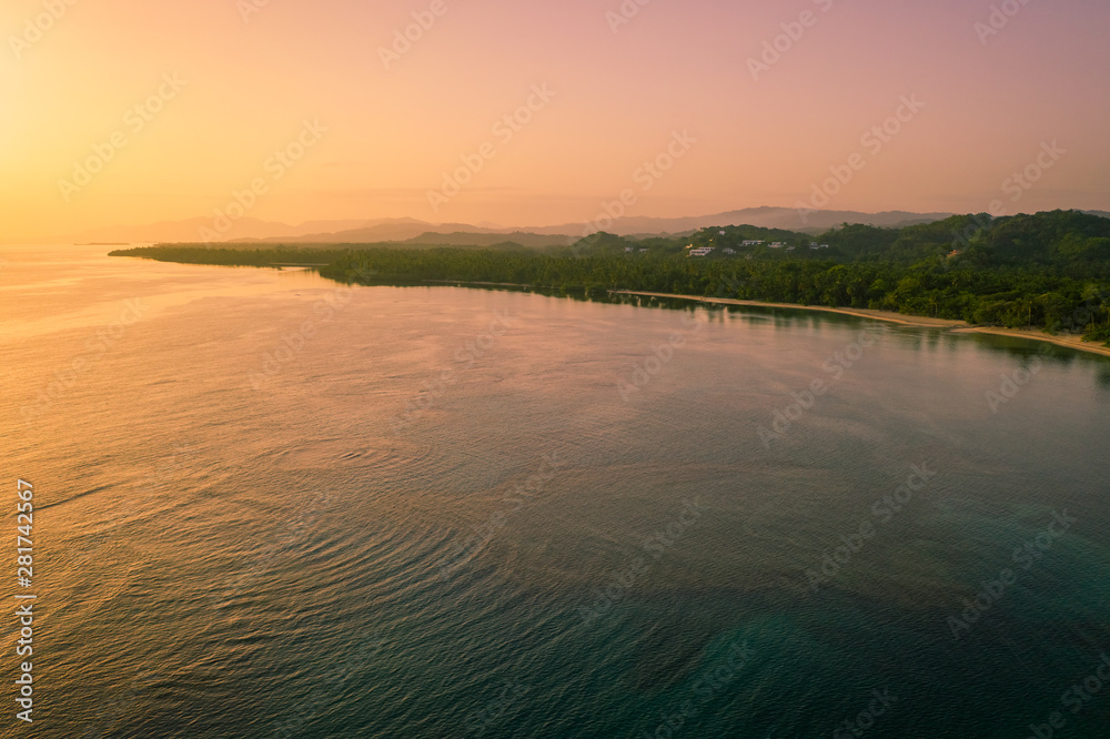 Fototapeta premium Drone shot of tropical beach at sunrise.Samana peninsula,Bahia Principe beach,Dominican Republic.