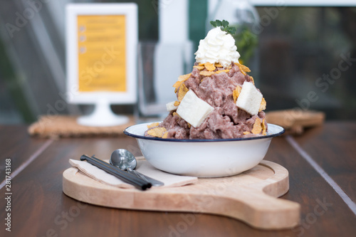 Snow ice cream cocoa dessert with milk sauce, bread, corn flake and whip cream topping.Traditional ice cream in Thai style sweet dessert