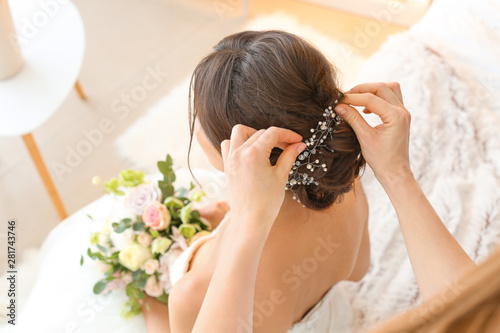 Professional hairdresser working with young bride at home