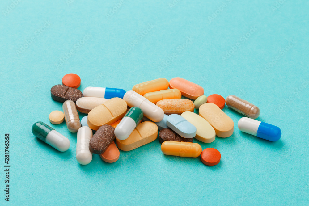 colour tablets and pills on blue background . colour tablets and pills on blue background .