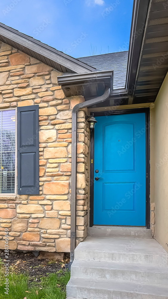 Vertical frame Home with stairs blue front door stone wall and windows with wooden shutters Vertical frame Home with stairs blue front door stone wall and windows with wooden shutters