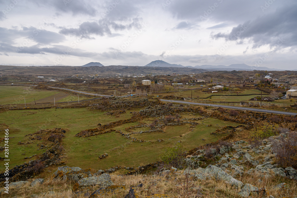 View of the old village from the top of the mountain on a cloudy day with mountains on the horizon.