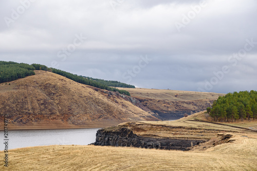 Mountain reservoir in the fall on a foggy cloudy autumn day with clouds in the sky. photo