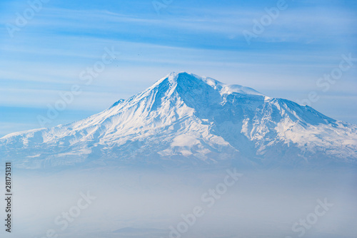 Mount Ararat is located on the Turkish territory with a view from the territory of Armenia from a high mountain near the Khor Virap monastery on a bright sunny day, with a hazy mist on the sky in the  © StockAleksey