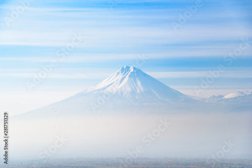 Mount Ararat is located on the Turkish territory with a view from the territory of Armenia from a high mountain near the Khor Virap monastery on a bright sunny day, with a hazy mist on the sky in the 