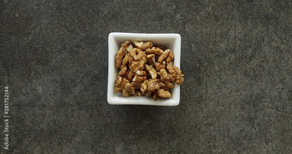 Male hand picking walnut from white square bowl closeup. Healthy food concept. 4k footage Male hand picking walnut from white square bowl closeup. Healthy food concept. 4k footage