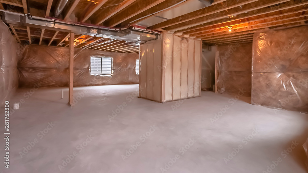 Fototapeta premium Panorama Home under construction with interior framing beams and plastic covered wall