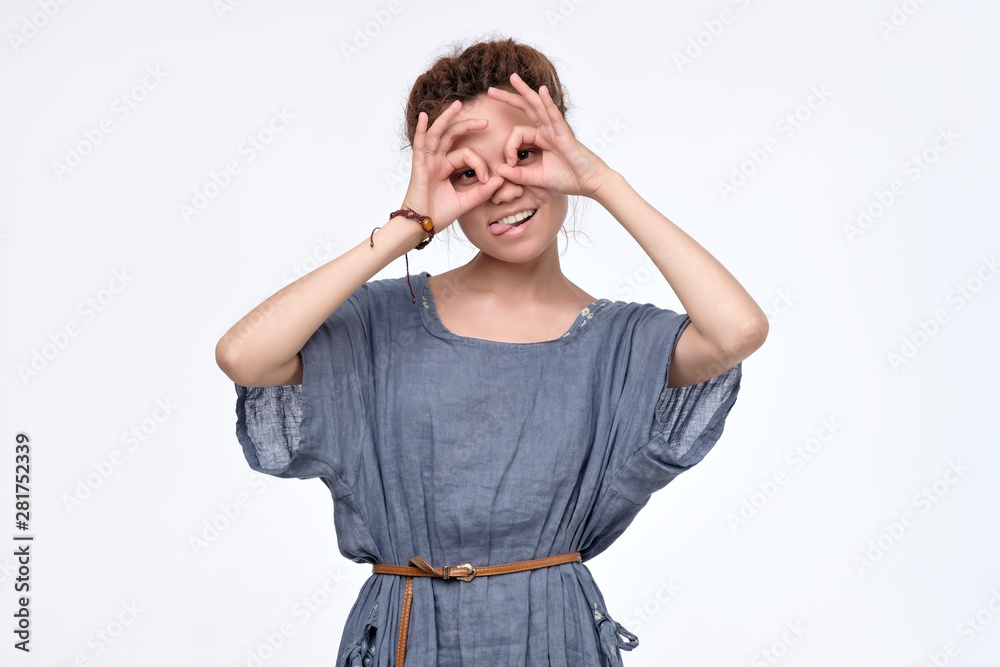 Pretty girl holding fingers near eyes like glasses:. Mask like super hero or owl. I need new lens concept. Pretty girl holding fingers near eyes like glasses:. Mask like super hero or owl. I need new lens concept.