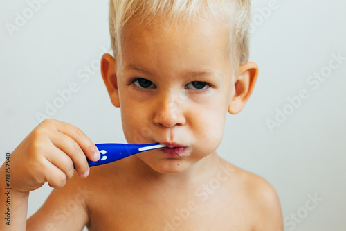 Portrait of a smiling little boy brushing his teeth