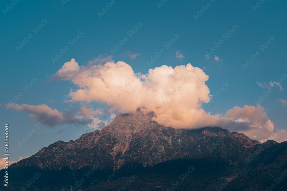 A cloud hides the peak of the mountain 