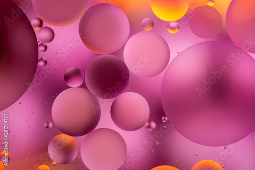 bright oily drops in water with colorful background, close-up 