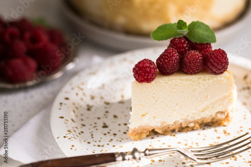 Slice Of Classical New York Cheesecake with raspberries On White Plate. Closeup View. Home bakery concept