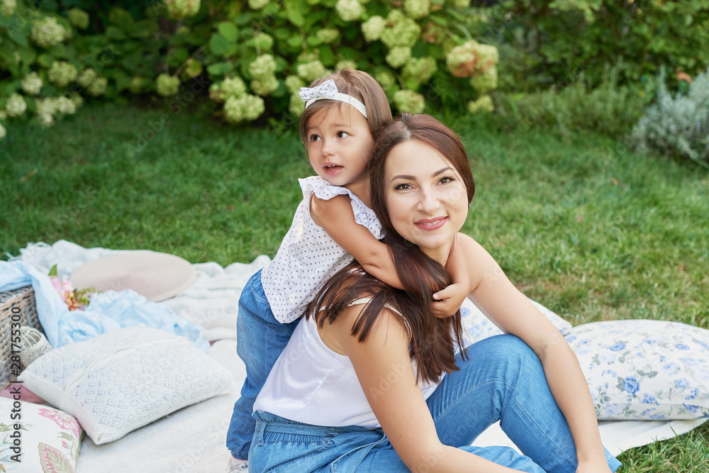 family mom and child daughter at a picnic in the garden in summer family mom and child daughter at a picnic in the garden in summer