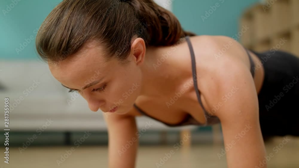 Fitness woman doing plank exercise at living room