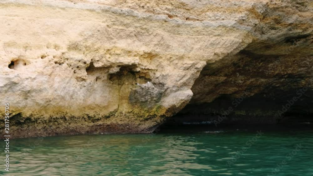 Tracking shot revealing beautiful sea caves off the coast of Portimao, The Algarve, Portugal with amazing turquoise waters Tracking shot revealing beautiful sea caves off the coast of Portimao, The Algarve, Portugal with amazing turquoise waters