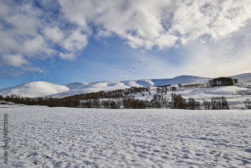 Looking West from Glen Clova, which lies at the heart of the Angus Glens in Scotland. A recent snowfall covers the Fields and hills with snow.
