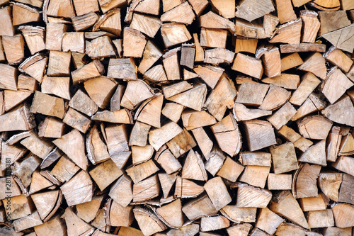 Background of chopped  sawn and stabbed stacked wooden logs.