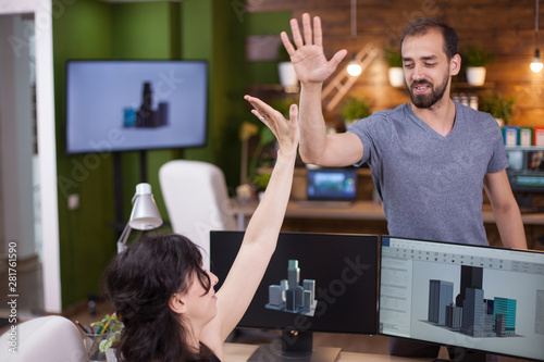 Two successful young business partners give a hi5 to each other photo