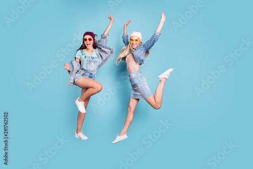 Full length body size view of nice-looking attractive slim fit carefree cheerful cheery glad girls having fun rejoicing action motion isolated over bright vivid shine blue green turquoise background