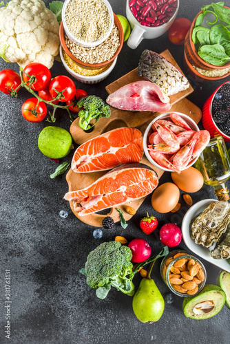Pescetarian diet plan ingredients, healthy balanced grocery food, fresh fruit, berries, fish and shellfish clams, black background copy space 