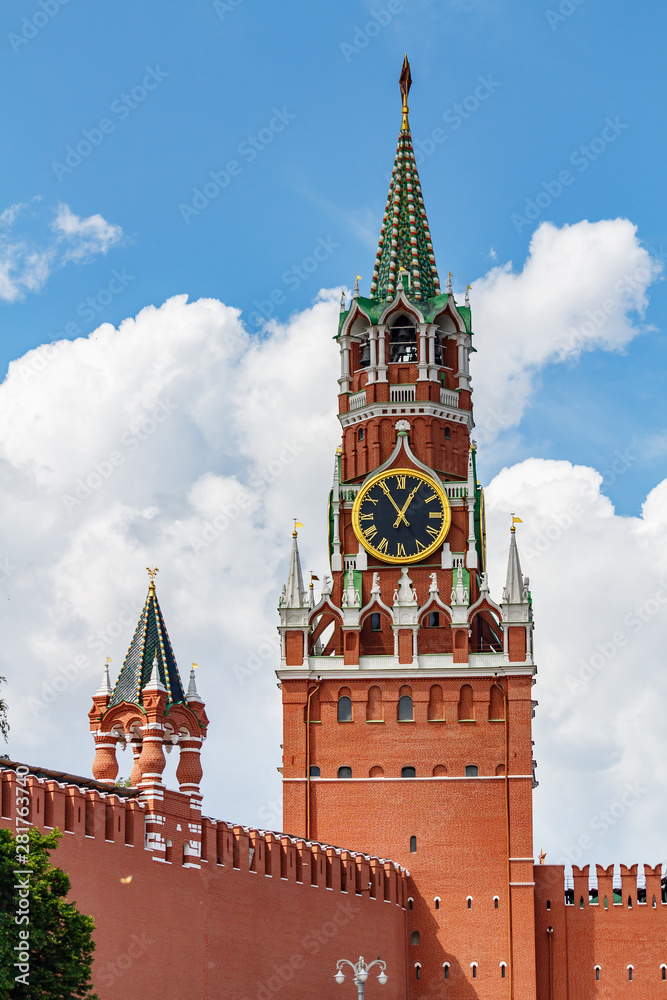Spasskaya tower of Moscow Kremlin on a background of blue sky with white clouds in sunny day Spasskaya tower of Moscow Kremlin on a background of blue sky with white clouds in sunny day