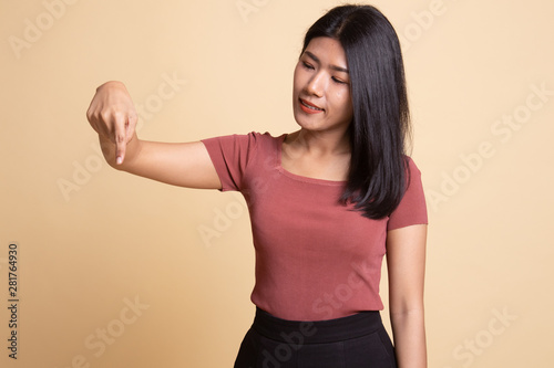 Beautiful young Asian woman point down to blank space.