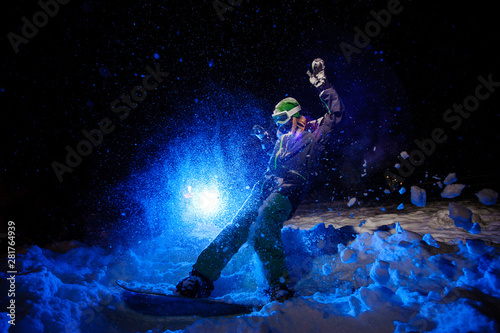 Female snowboarder dressed in a green sportswear riding on the mountain slope © fesenko