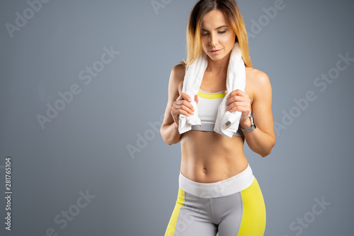 Portrait of a beautiful young sporty  woman against gray background © fotofabrika
