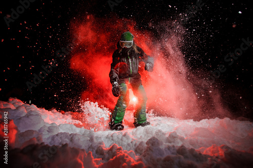 Active female snowboarder dressed in a green sportswear standing on the snow slope