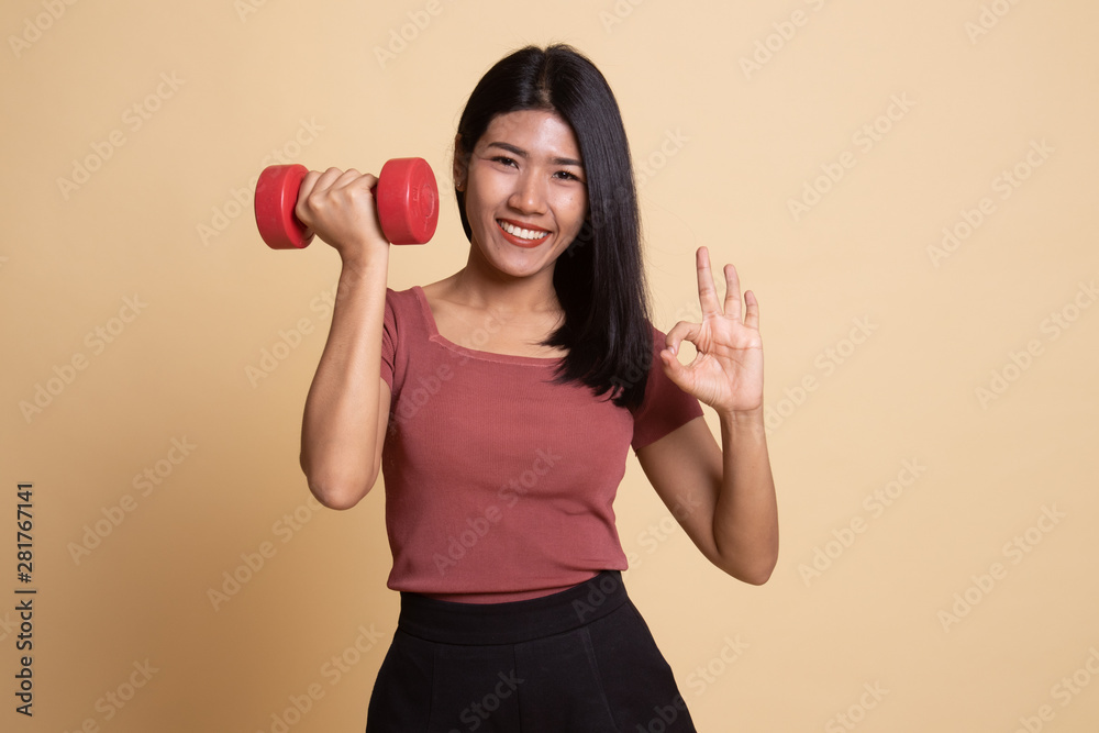 Healthy Asian woman show OK with dumbbells. Healthy Asian woman show OK with dumbbells.