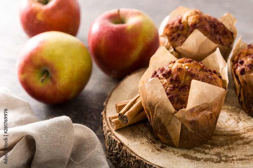 Apples and cinnamon muffins on wooden table