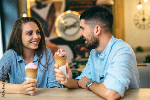 couple having fun eating ice cream in cafe