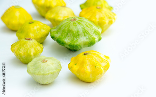 Squash vegetable. Group of green and yellow pattypan squashes, on white table background.