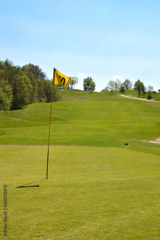 Obraz premium Putting green with golf flagstick on a golf course