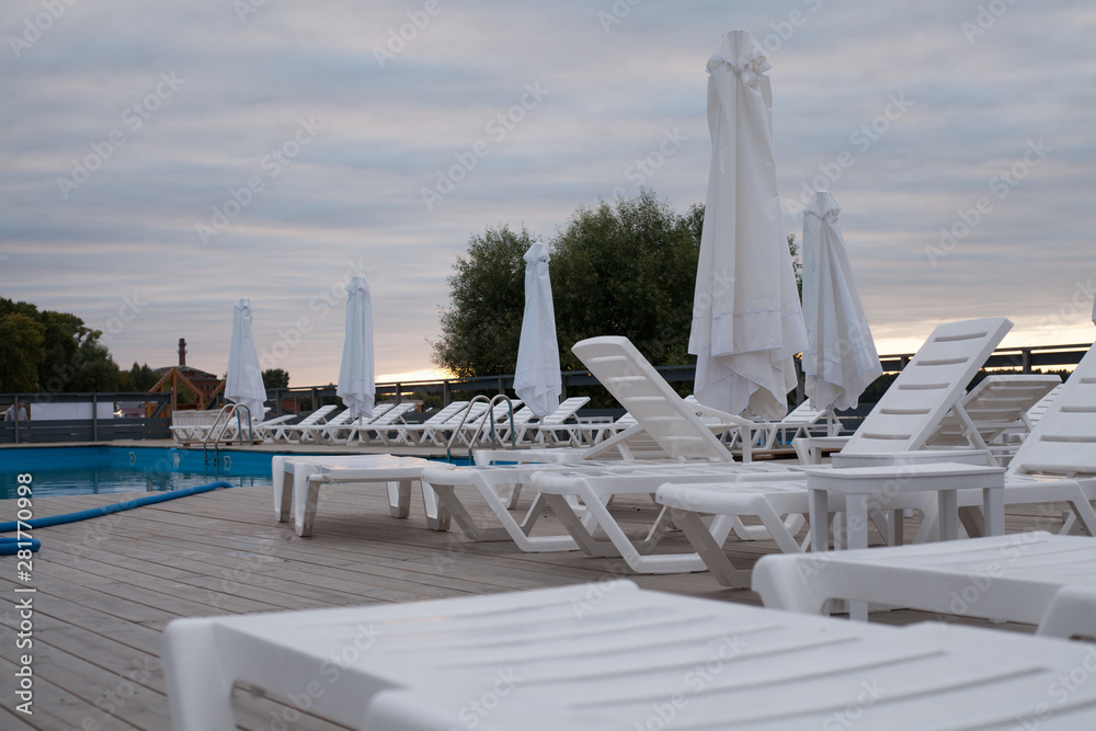 Fototapeta premium Hotel lounge area with swimming pool and sun loungers