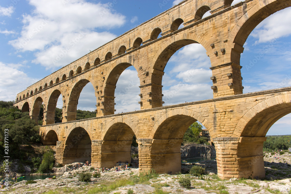 Beautiful view of Pont du Gard, the highest Roman aqueduct in Europe, a sunny summer day. This three-tiered bridge is located in Provence, in south of France, over the Gardon river. – Image