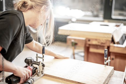 Schilderij op canvas junge Handwerkerin arbeitet mit der Lamellofräse in der Schreinerei